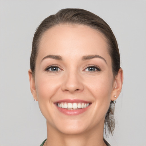 Joyful white young-adult female with medium  brown hair and grey eyes