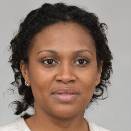 Joyful black adult female with medium  brown hair and brown eyes
