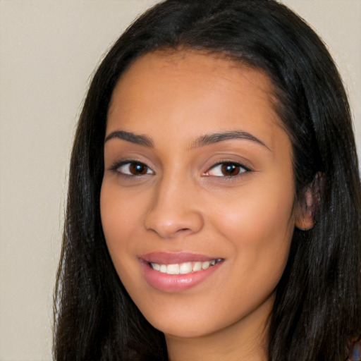 Joyful latino young-adult female with long  black hair and brown eyes