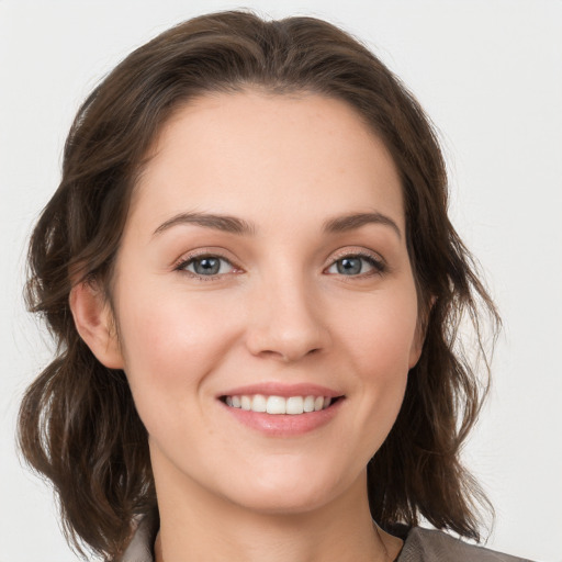 Joyful white young-adult female with medium  brown hair and grey eyes