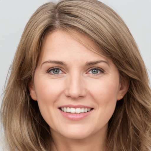 Joyful white young-adult female with long  brown hair and grey eyes