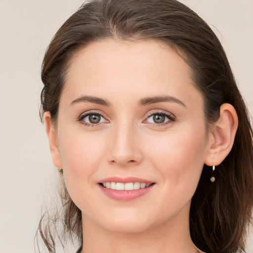 Joyful white young-adult female with long  brown hair and grey eyes