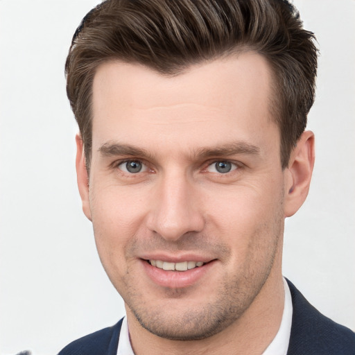 Joyful white young-adult male with short  brown hair and grey eyes