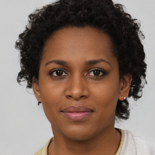 Joyful black young-adult female with short  brown hair and brown eyes
