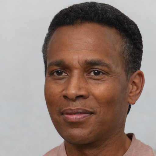 Joyful black adult male with short  black hair and brown eyes