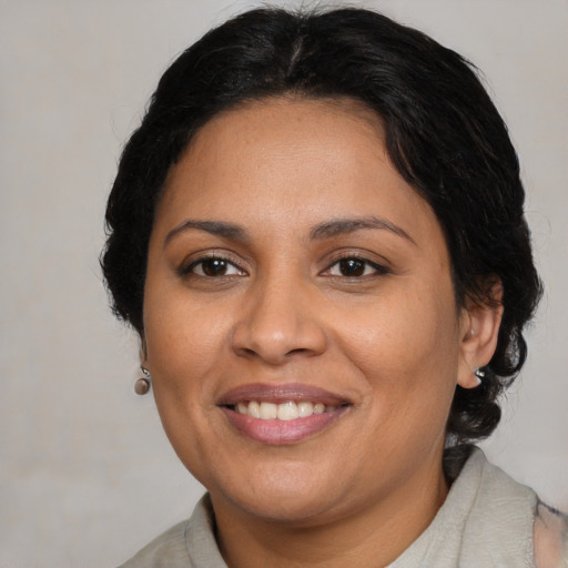 Joyful latino adult female with medium  brown hair and brown eyes