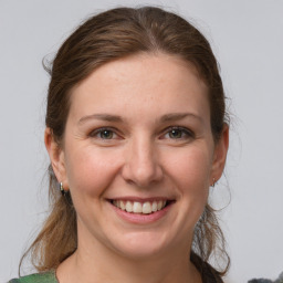 Joyful white young-adult female with medium  brown hair and grey eyes