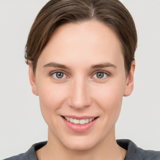 Joyful white young-adult female with short  brown hair and grey eyes