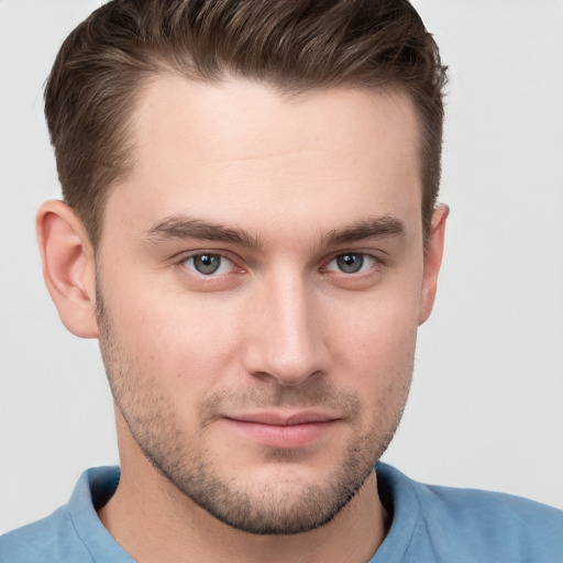 Joyful white young-adult male with short  brown hair and grey eyes