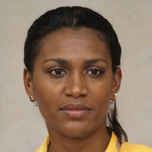 Joyful black young-adult female with short  black hair and brown eyes
