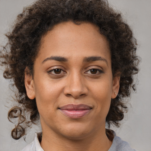 Joyful latino adult female with medium  brown hair and brown eyes