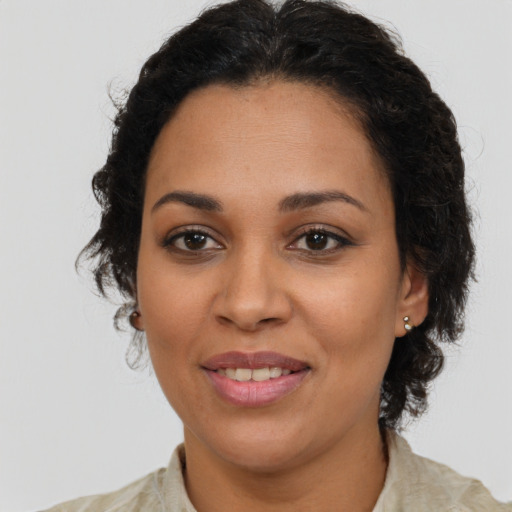 Joyful latino adult female with medium  brown hair and brown eyes