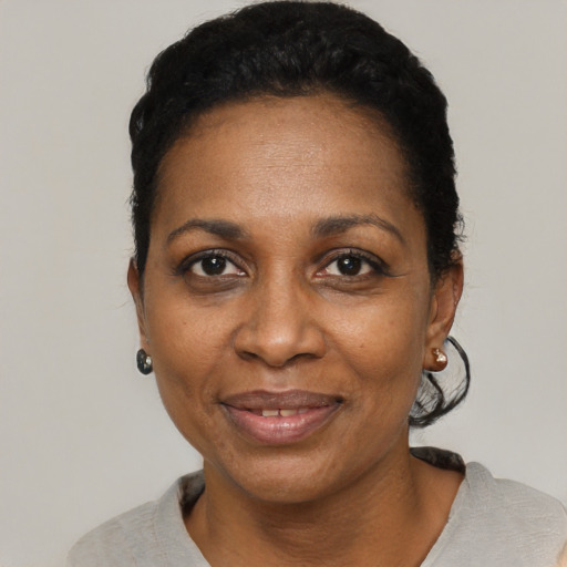Joyful black adult female with short  black hair and brown eyes
