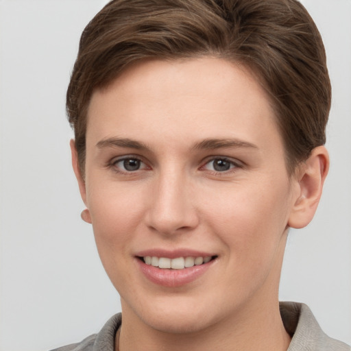 Joyful white young-adult female with short  brown hair and grey eyes