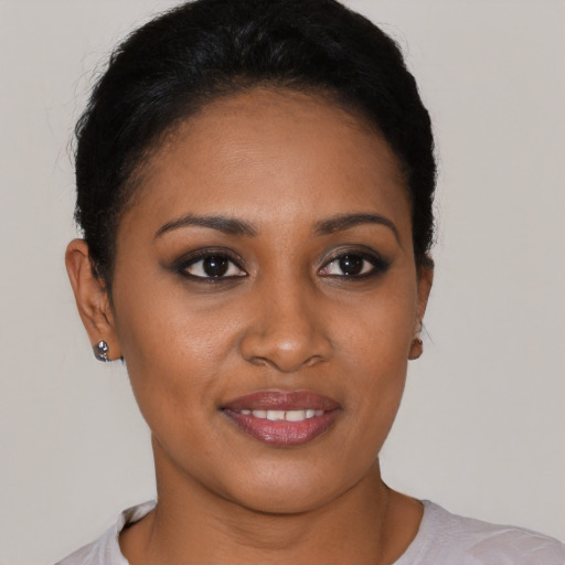 Joyful black young-adult female with short  black hair and brown eyes