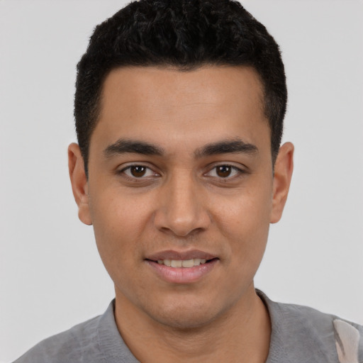 Joyful latino young-adult male with short  black hair and brown eyes