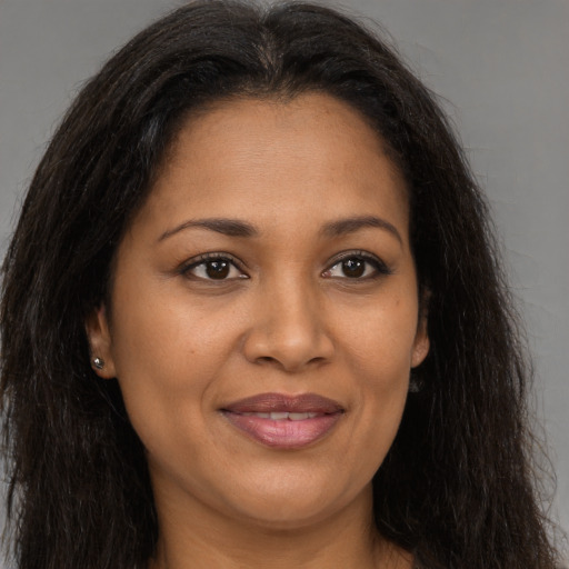 Joyful black young-adult female with long  brown hair and brown eyes