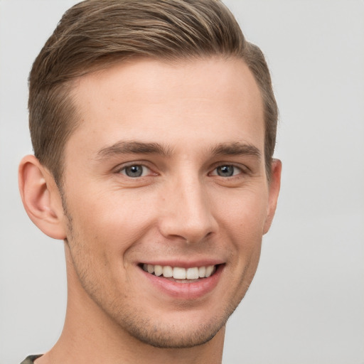 Joyful white young-adult male with short  brown hair and grey eyes