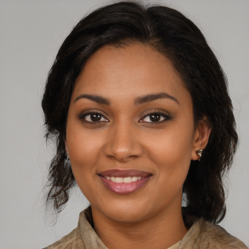 Joyful black young-adult female with medium  brown hair and brown eyes