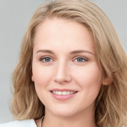 Joyful white young-adult female with long  brown hair and blue eyes