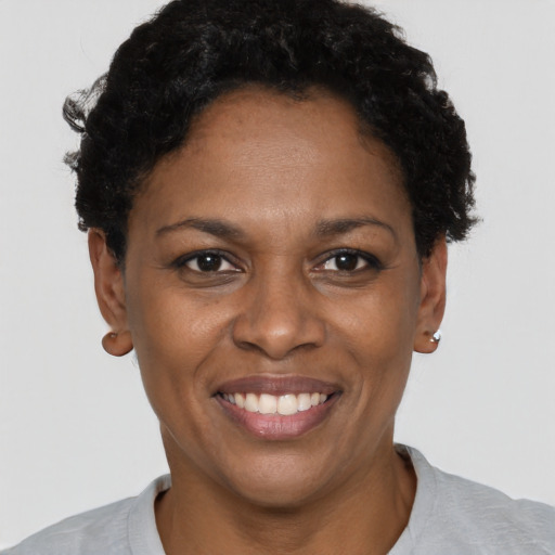 Joyful black young-adult female with short  black hair and brown eyes