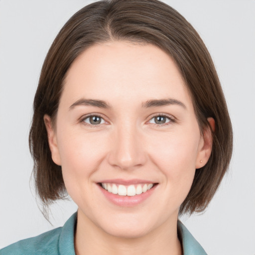 Joyful white young-adult female with medium  brown hair and grey eyes