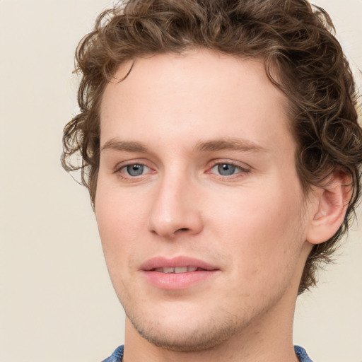 Joyful white young-adult male with short  brown hair and blue eyes