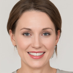 Joyful white young-adult female with medium  brown hair and grey eyes