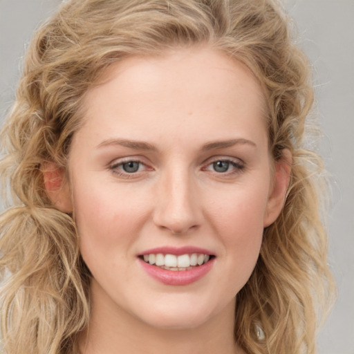 Joyful white young-adult female with long  brown hair and blue eyes