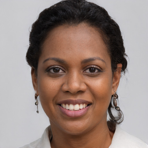 Joyful black young-adult female with short  brown hair and brown eyes