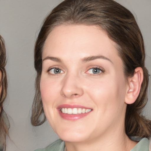 Joyful white young-adult female with medium  brown hair and blue eyes