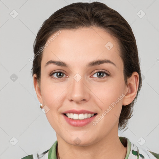 Joyful white young-adult female with medium  brown hair and green eyes