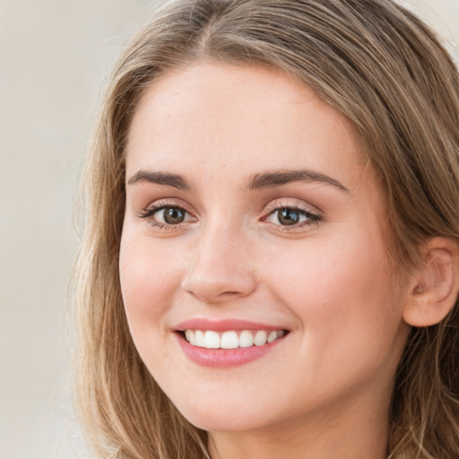 Joyful white young-adult female with long  brown hair and green eyes