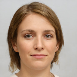 Joyful white young-adult female with medium  brown hair and green eyes