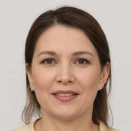 Joyful white adult female with medium  brown hair and grey eyes