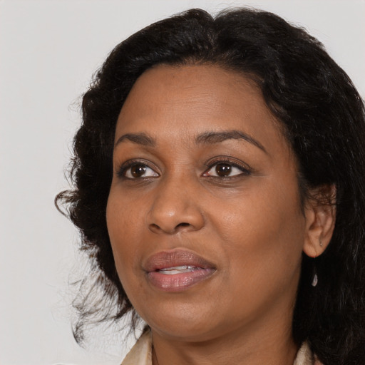Joyful black adult female with medium  brown hair and brown eyes