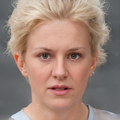 Joyful white adult female with short  blond hair and blue eyes