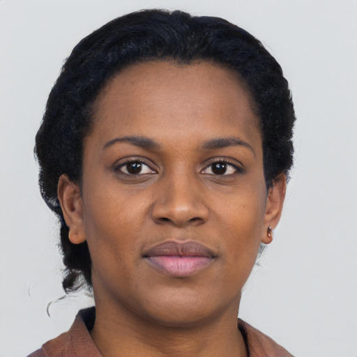 Joyful black young-adult female with short  black hair and brown eyes