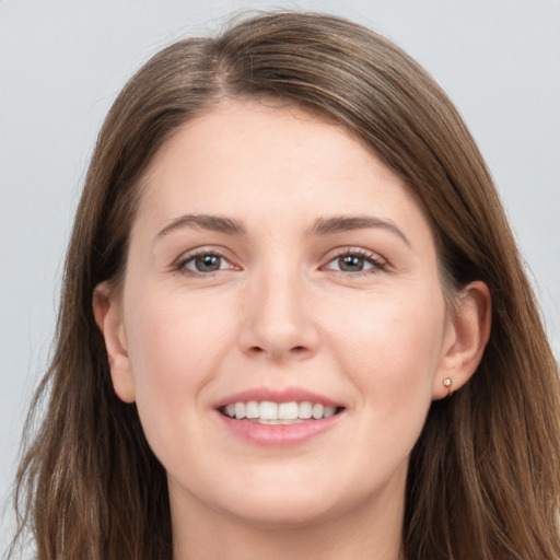 Joyful white young-adult female with long  brown hair and grey eyes