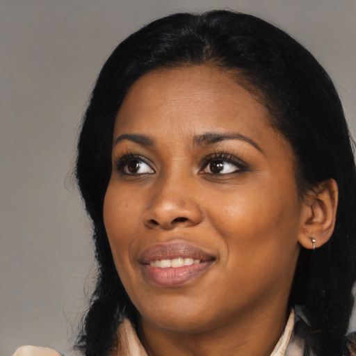 Joyful black young-adult female with long  black hair and brown eyes