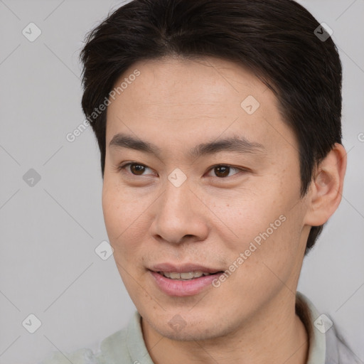 Joyful asian young-adult male with short  brown hair and brown eyes