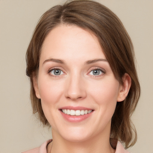 Joyful white young-adult female with medium  brown hair and grey eyes