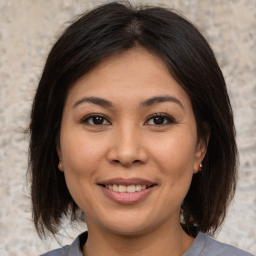 Joyful asian young-adult female with medium  brown hair and brown eyes