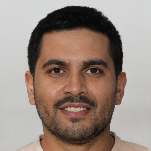 Joyful latino young-adult male with short  black hair and brown eyes