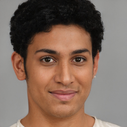 Joyful latino young-adult male with short  brown hair and brown eyes