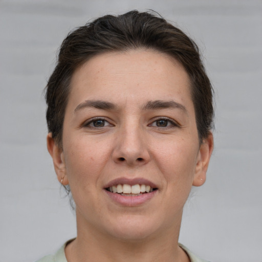 Joyful white young-adult female with short  brown hair and grey eyes