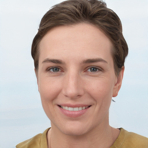 Joyful white young-adult female with short  brown hair and grey eyes