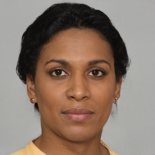 Joyful black young-adult female with short  brown hair and brown eyes
