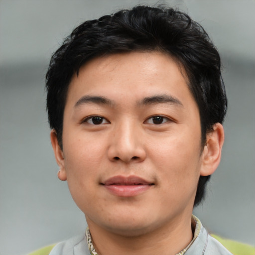 Joyful asian young-adult male with short  black hair and brown eyes