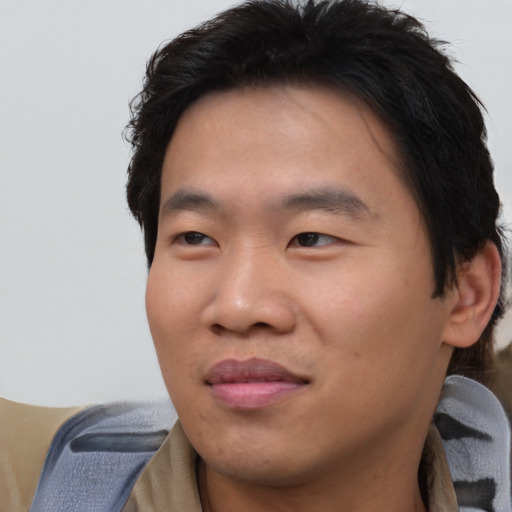 Joyful asian young-adult male with short  brown hair and brown eyes